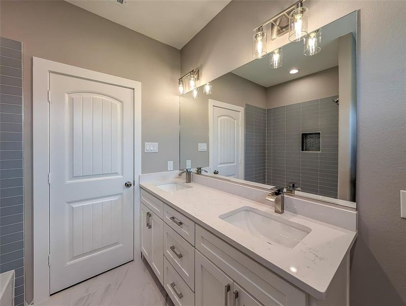 Hall Bath with 42 in storage cabinets plus top boxes for extra storage. Designer tile with built in soap ledge