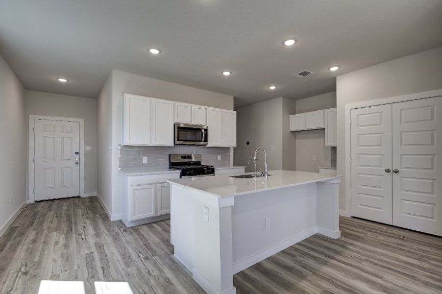 A kitchen with white cabinets.