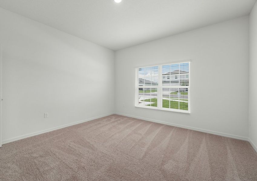 Spacious master bedroom with a large window