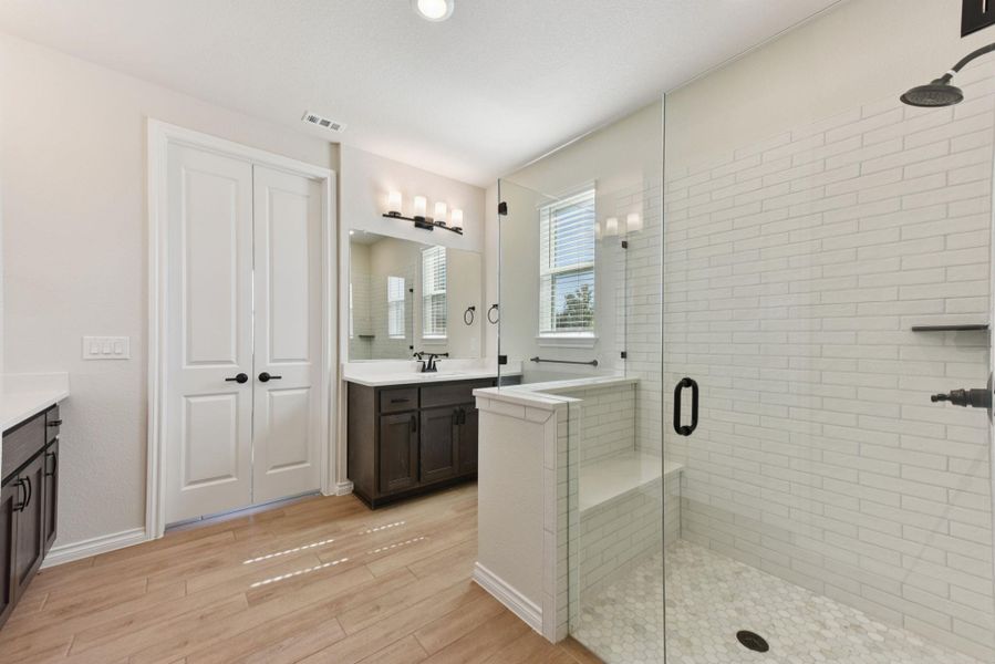 Bathroom with vanity, light wood-type flooring, a shower stall, and recessed lighting