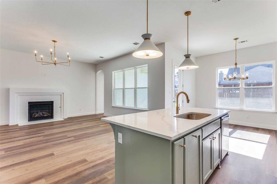 Kitchen featuring a center island with sink, wood-type flooring, a healthy amount of sunlight, and sink