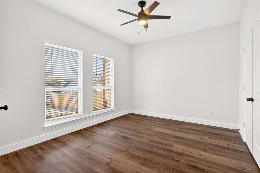 Spare room with dark wood-style flooring and a ceiling fan