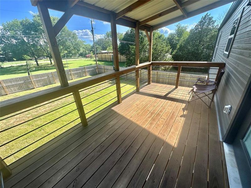 Wooden terrace with a fenced backyard and view of scattered trees Wooden terrace with a fenced backyard and view of scattered trees