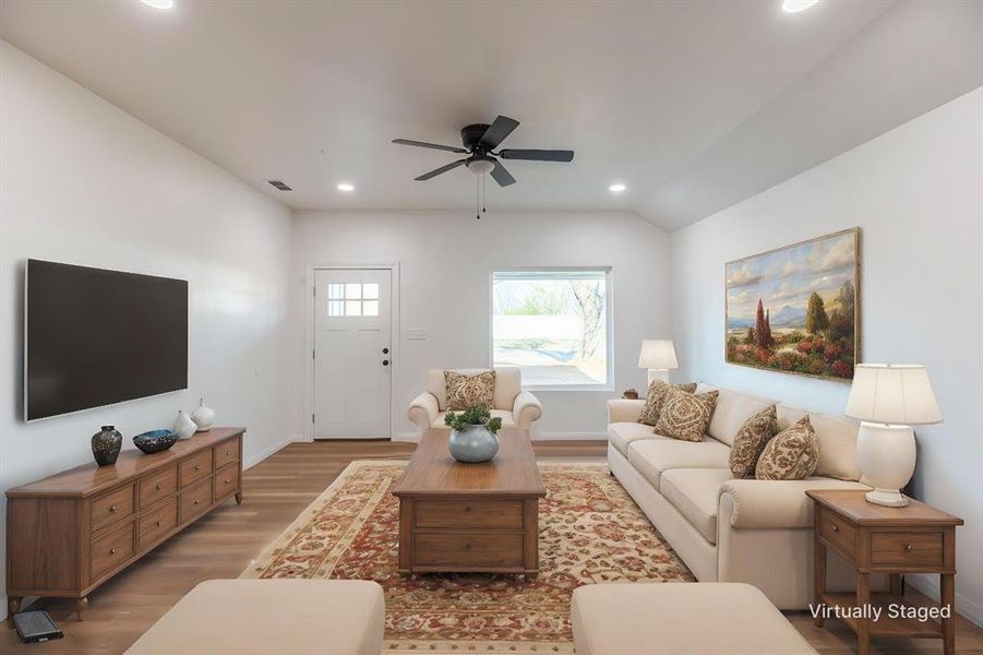 Living room with wood finished floors, a ceiling fan, and recessed lighting