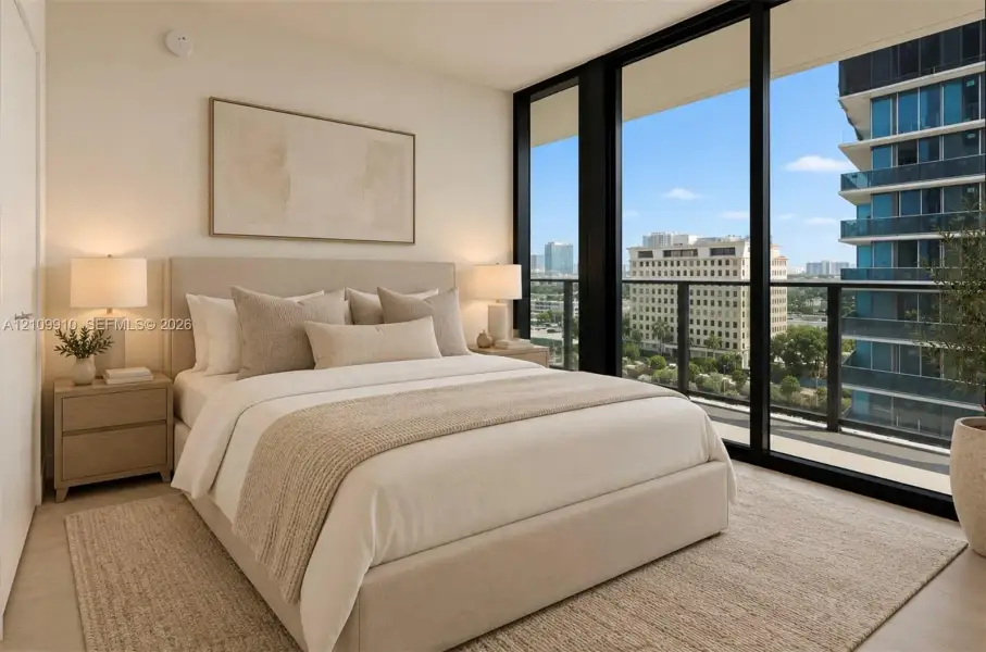 Floor-to-ceiling windows featuring urban scenery and access to an exterior balcony with a metal railing, complemented by neutral-toned interior walls and wood-finish flooring