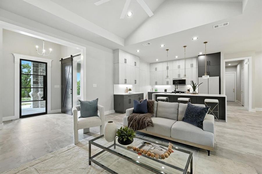 Living room with a barn door, high vaulted ceiling, recessed lighting, and a chandelier