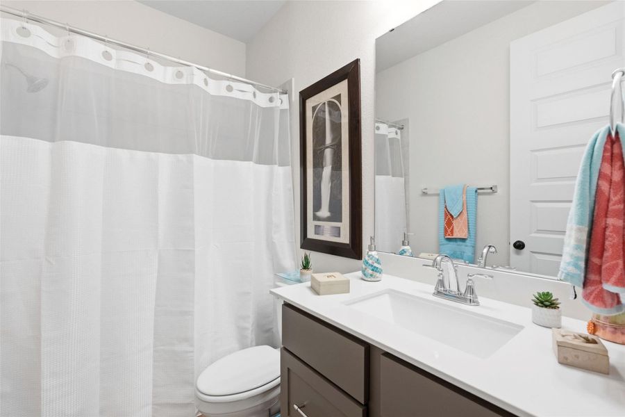 Bathroom featuring a single vanity with a white countertop, chrome faucet, and a large mirror