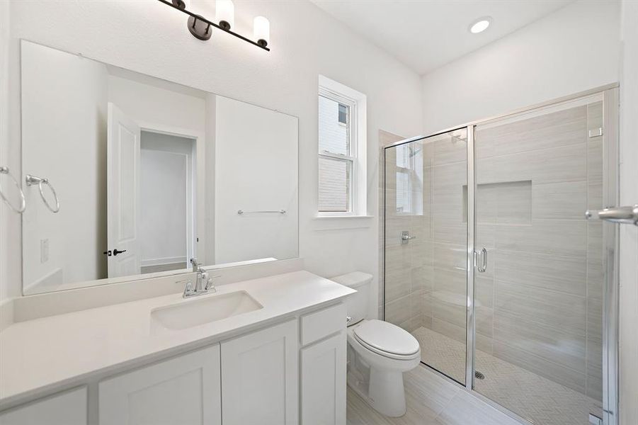 Bathroom featuring a shower stall and vanity Bathroom featuring a shower stall and vanity