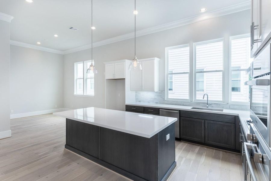 Never lacking for light in this kitchen and plenty of room for barstools. Similar plan and finishes.