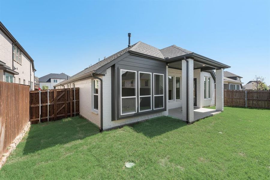 Back of house featuring brick siding, roof with shingles, a patio area, and a fenced backyard Back of house featuring brick siding, roof with shingles, a patio area, and a fenced backyard