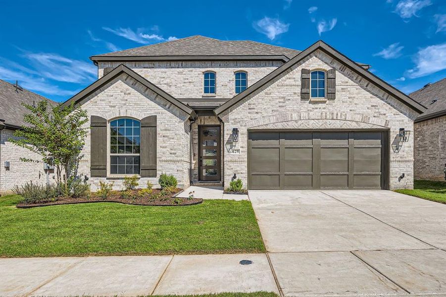 French country inspired facade featuring a front yard