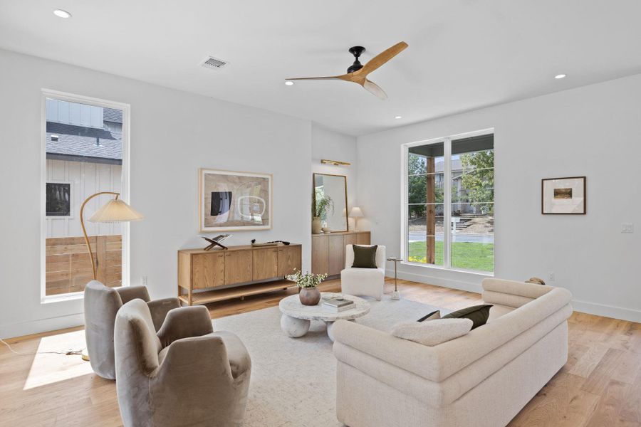 Living area with recessed lighting, light wood-style floors, and a ceiling fan Living area with recessed lighting, light wood-style floors, and a ceiling fan