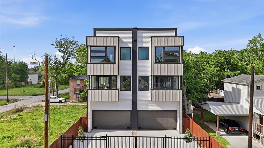 Striking three-story modern duplex featuring sleek contemporary design, oversized windows, private garages, and gated entry, offering exceptional curb appeal and urban convenience.