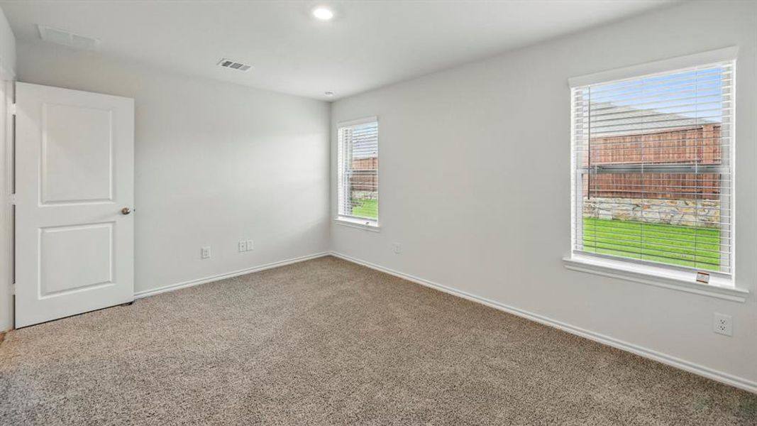 Carpeted room featuring white walls, white trim, and two windows with blinds