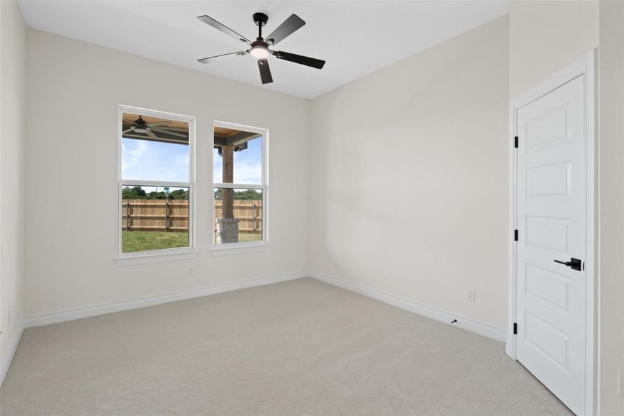 Empty room featuring light colored carpet and ceiling fan Empty room featuring light colored carpet and ceiling fan