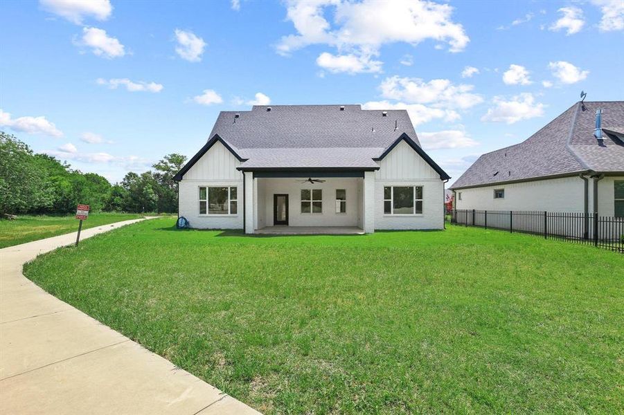 Modern farmhouse-style exterior featuring white siding, black trim, and a covered back patio Modern farmhouse-style exterior featuring white siding, black trim, and a covered back patio