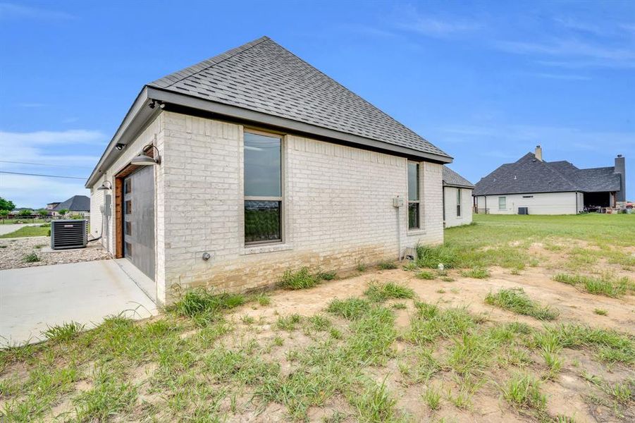 Rear view of property featuring a lawn and a garage