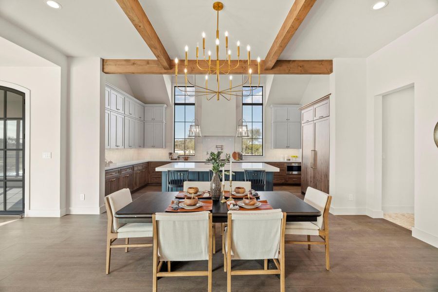 Dining space with sparkling chandelier and lofted beamed ceilings.