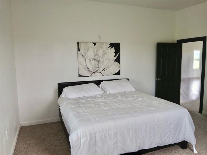 Bedroom featuring carpet floors and baseboards Bedroom featuring carpet floors and baseboards