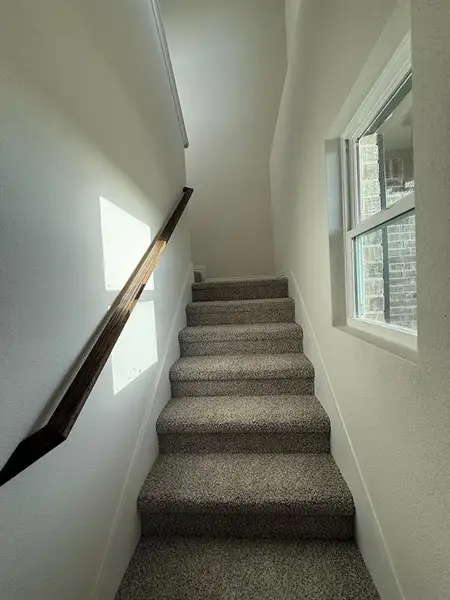 Staircase featuring a textured wall by entry door Staircase featuring a textured wall by entry door