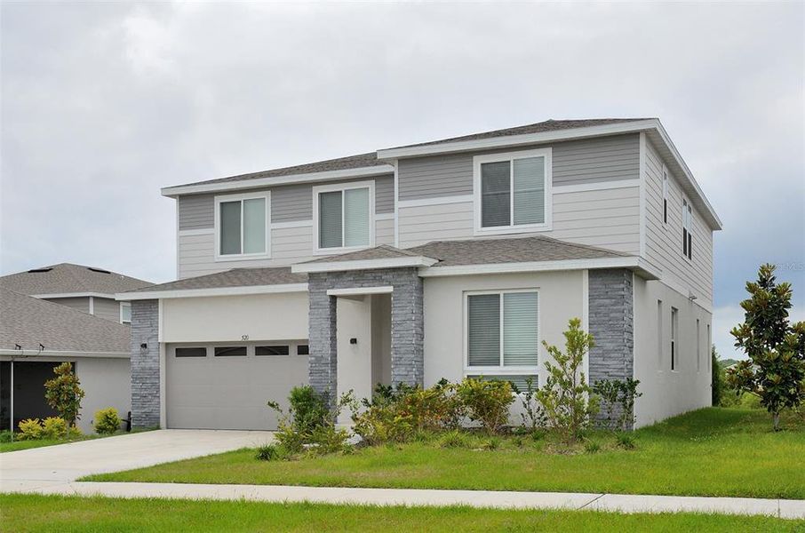 Front exterior of a new home in Seasons at Eden Hills, Lake Alfred, FL, highlighting curb appeal (Image 24).