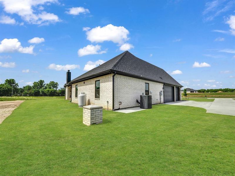 View of property exterior with driveway, central AC unit, a garage, a lawn, and brick siding View of property exterior with driveway, central AC unit, a garage, a lawn, and brick siding