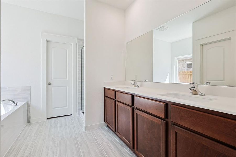 Bathroom with double vanity, a bath, and a shower stall