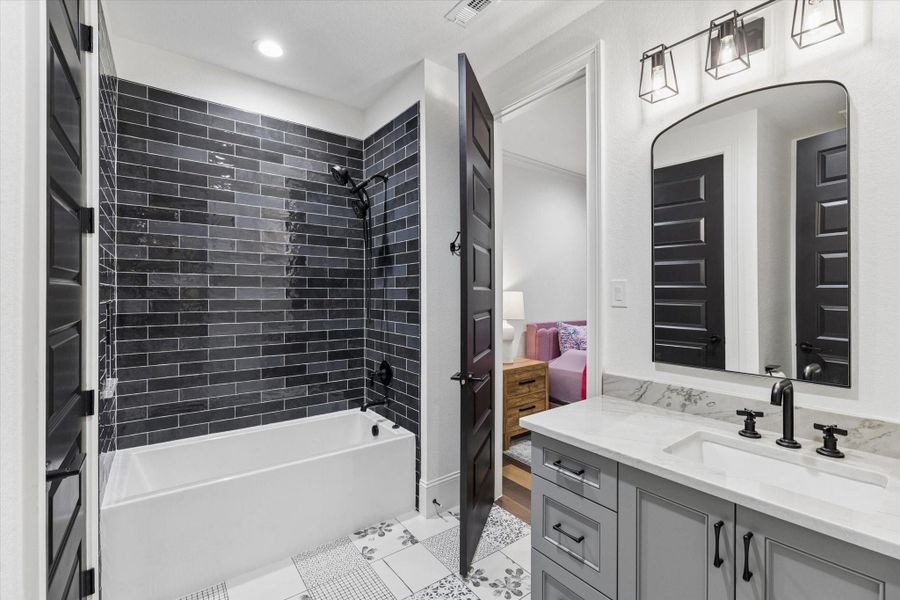 Elegant cabinetry, refined fixtures, and contemporary finishes create a secondary bath that feels polished and inviting while maintaining the home's consistent standard of luxury.