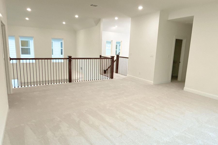 Unfurnished room with light carpet, recessed lighting, and healthy amount of natural light