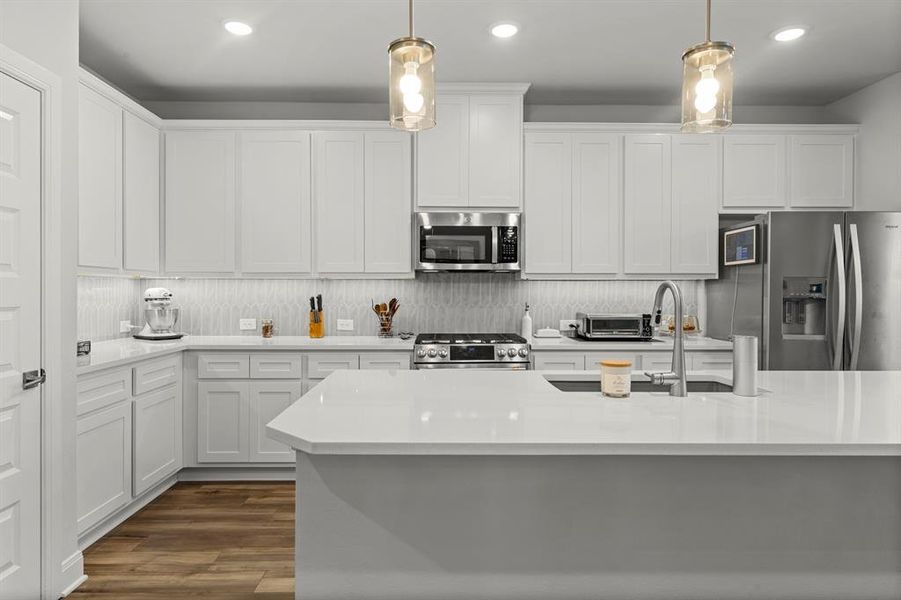 Kitchen with stainless steel appliances, white cabinetry, tasteful backsplash, and recessed lighting Kitchen with stainless steel appliances, white cabinetry, tasteful backsplash, and recessed lighting