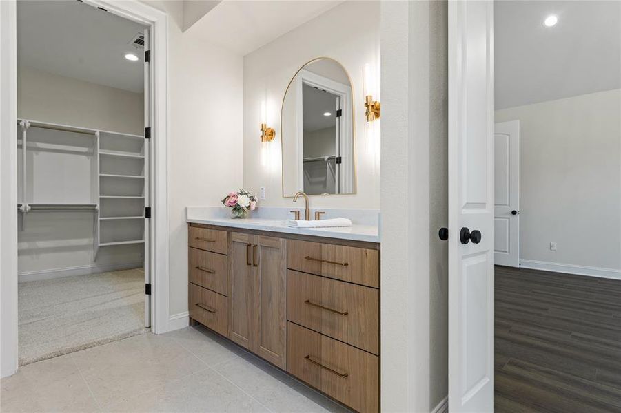 Full bathroom featuring vanity, a spacious closet, and recessed lighting
