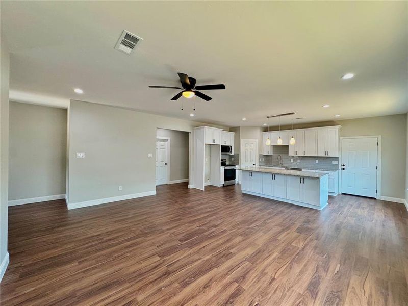 Unfurnished living room featuring hardwood / wood-style flooring and ceiling fan