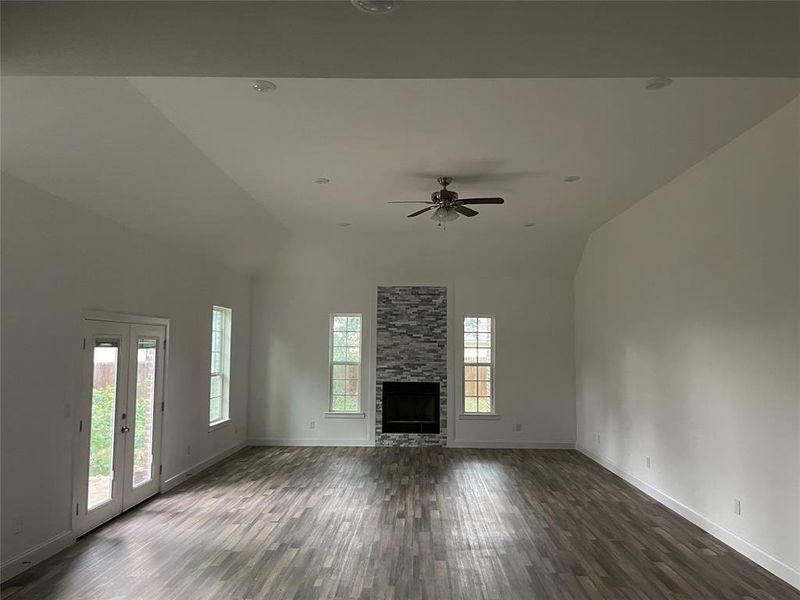living room with wood like tile, high vaulted ceiling, and baseboards
