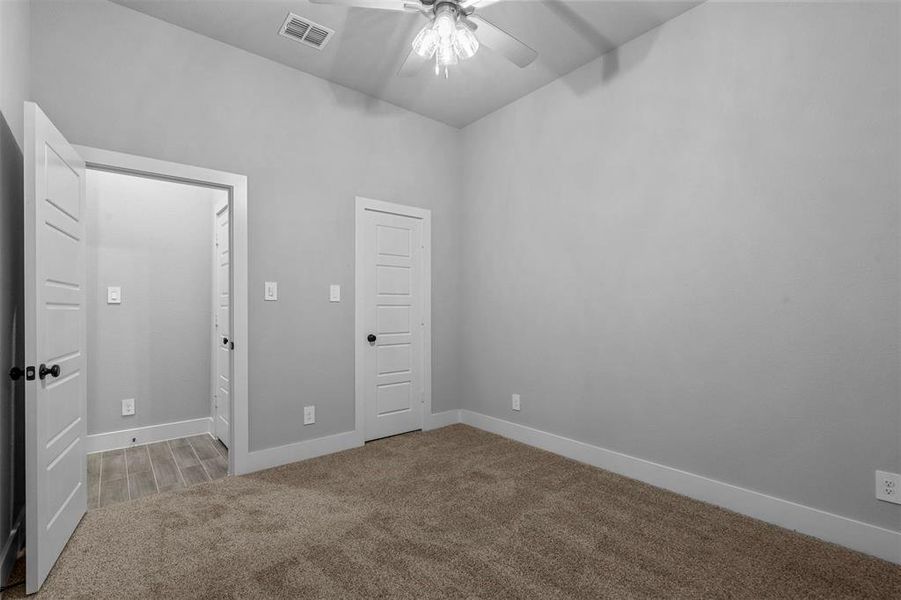 Unfurnished bedroom with light carpet and ceiling fan