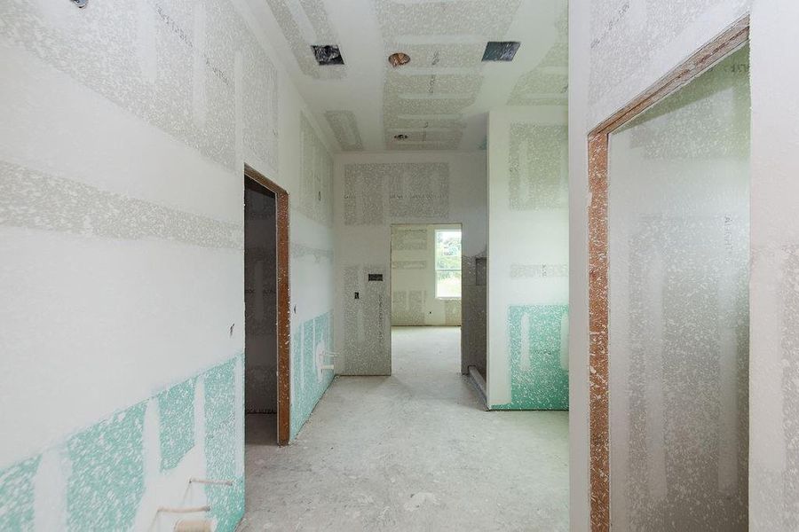 Spacious primary bathroom in the midst of construction, featuring freshly installed drywall and potential for customization. Spacious primary bathroom in the midst of construction, featuring freshly installed drywall and potential for customization.
