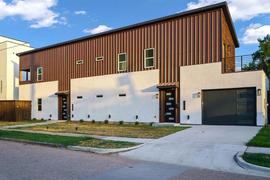 View of front of house featuring concrete driveway, a garage, board and batten siding, and stucco siding