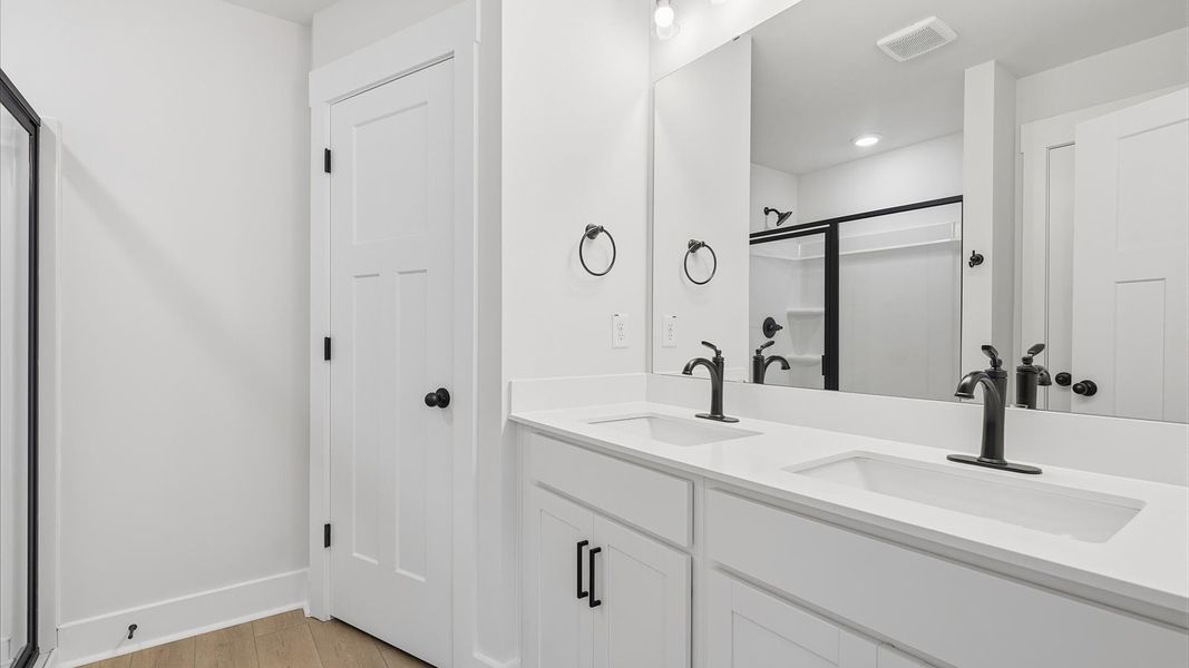 Accomplished design shines in this primary bath with dual vanity and a sleek walk-in shower at Marion Square Accomplished design shines in this primary bath with dual vanity and a sleek walk-in shower at Marion Square