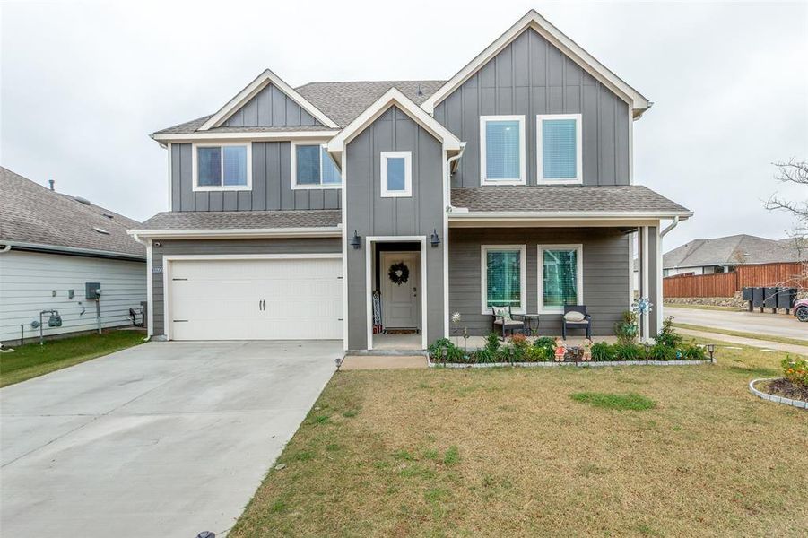 View of front of house featuring board and batten siding, a shingled roof, concrete driveway, a front lawn, and covered porch View of front of house featuring board and batten siding, a shingled roof, concrete driveway, a front lawn, and covered porch