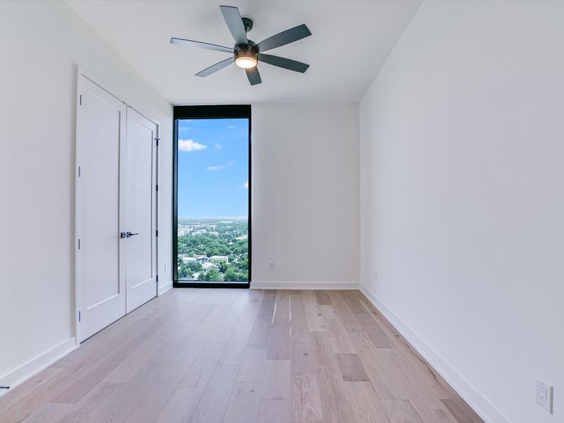 Secondary bedroom with floor to ceiling window of east Austin.