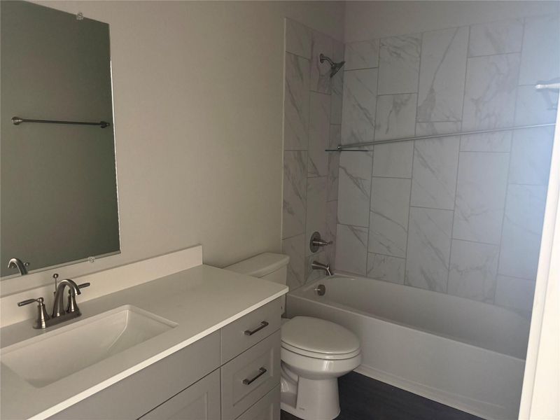 Marble-patterned wall tile and a modern grey vanity define this stylish bathroom layout.