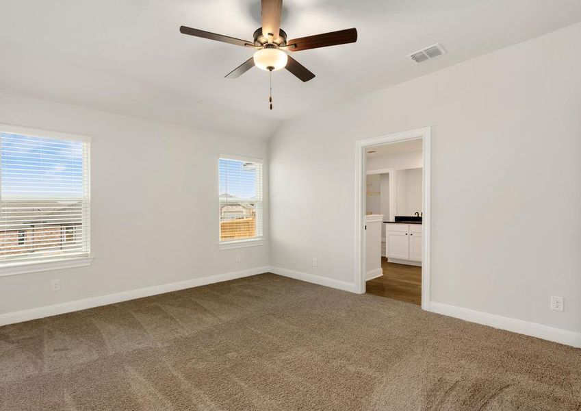 Master bedroom with two large windows and an attached bathroom.