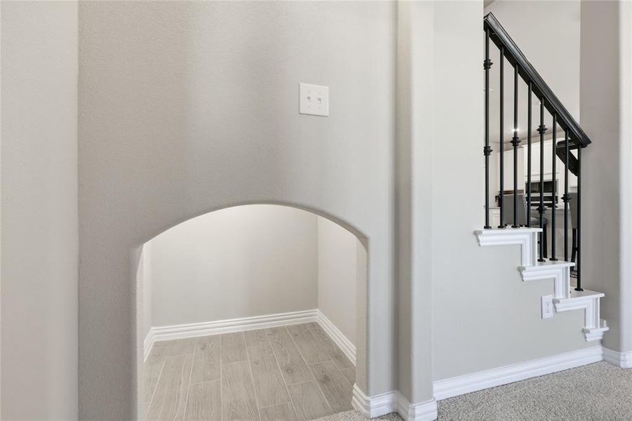 Arched under-stair alcove with wood-finish flooring