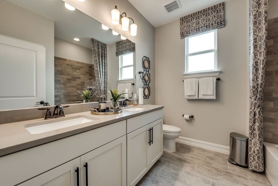 Secondary bathroom with tile-flooring and double v