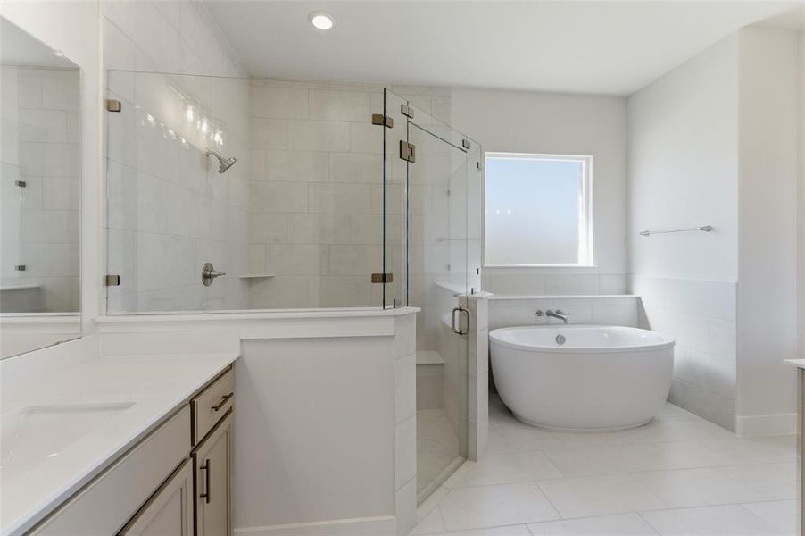 Full bathroom featuring vanity, a stall shower, a soaking tub, tile walls, and light tile patterned floors