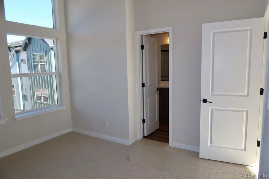 Bedroom 1 with walk-in closet, attached bath and high, slanted ceilings.