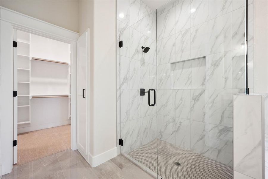 Bathroom featuring tile patterned floors and a shower with door