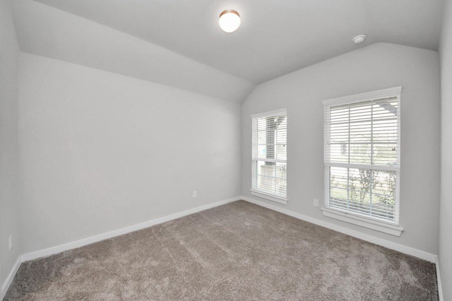 Bright fourth bedroom featuring large windows overlooking the front of the home and a private ensuite bathroom, ideal for guests or a private suite.