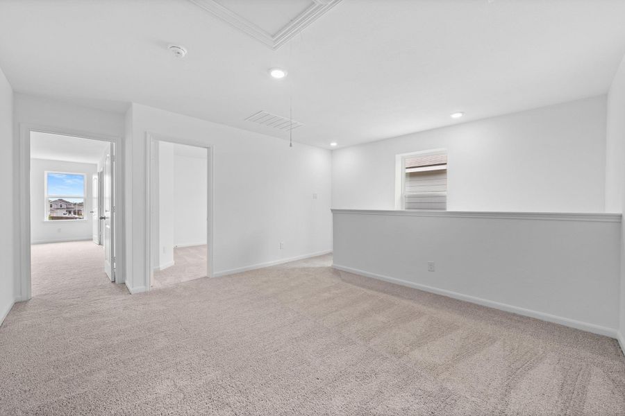 Spare room featuring light carpet, attic access, and recessed lighting