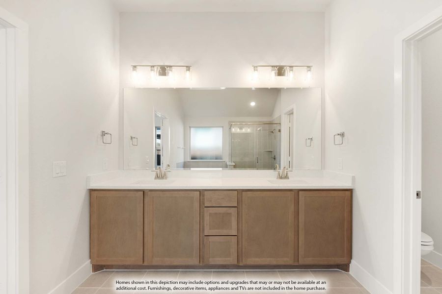 Bathroom with double-sink vanity, wood cabinets, white countertop, large mirror, and wall sconce lighting Bathroom with double-sink vanity, wood cabinets, white countertop, large mirror, and wall sconce lighting