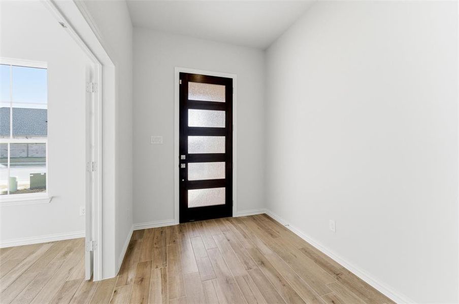 Foyer with light wood-style flooring and baseboards